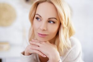 close up portrait of young beautiful blond woman dreaming about something