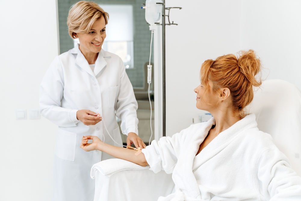 Beautiful woman in robe receives a therapeutic IV to boost her energy.