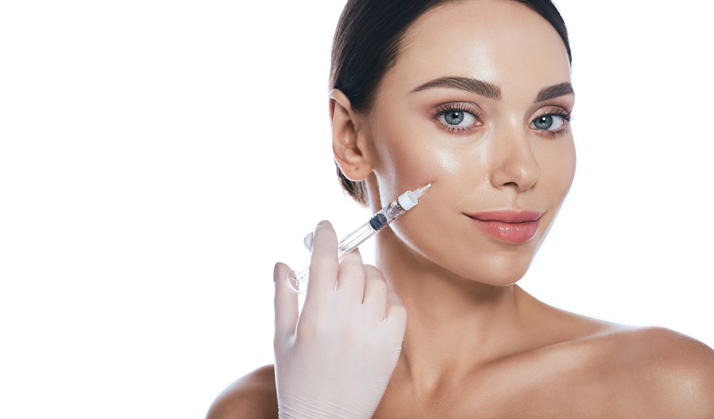 Woman enhances volume in her cheek with dermal filler injectable treatment.